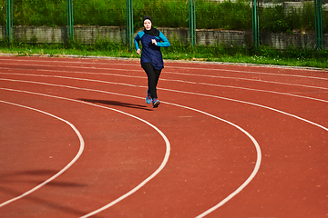 Image showing A muslim woman in a burqa sports muslim clothes running on a marathon course and preparing for upcoming competitions