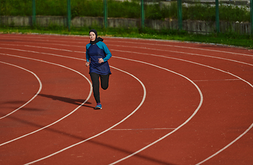 Image showing A muslim woman in a burqa sports muslim clothes running on a marathon course and preparing for upcoming competitions