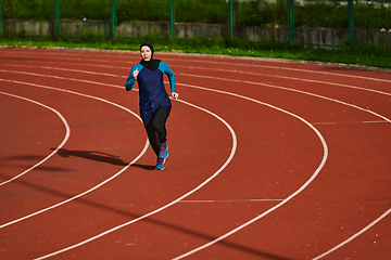 Image showing A muslim woman in a burqa sports muslim clothes running on a marathon course and preparing for upcoming competitions