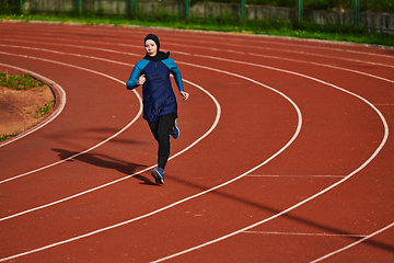 Image showing A muslim woman in a burqa sports muslim clothes running on a marathon course and preparing for upcoming competitions