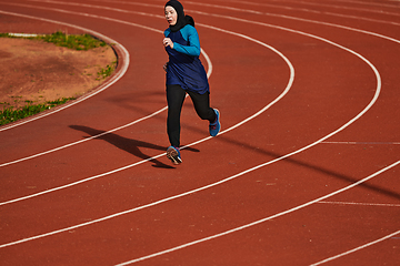 Image showing A muslim woman in a burqa sports muslim clothes running on a marathon course and preparing for upcoming competitions