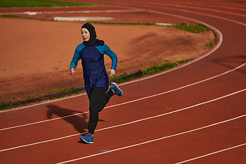 Image showing A muslim woman in a burqa sports muslim clothes running on a marathon course and preparing for upcoming competitions