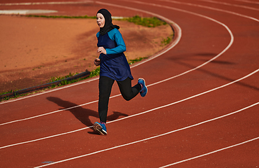 Image showing A muslim woman in a burqa sports muslim clothes running on a marathon course and preparing for upcoming competitions