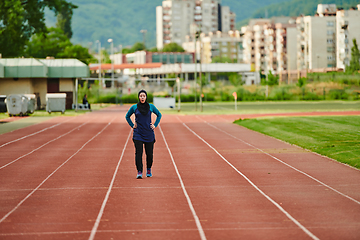 Image showing A muslim woman in a burqa sports muslim clothes running on a marathon course and preparing for upcoming competitions