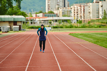 Image showing A muslim woman in a burqa sports muslim clothes running on a marathon course and preparing for upcoming competitions