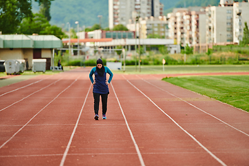 Image showing A muslim woman in a burqa sports muslim clothes running on a marathon course and preparing for upcoming competitions