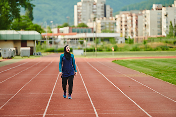 Image showing A muslim woman in a burqa sports muslim clothes running on a marathon course and preparing for upcoming competitions