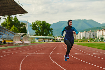 Image showing A muslim woman in a burqa sports muslim clothes running on a marathon course and preparing for upcoming competitions