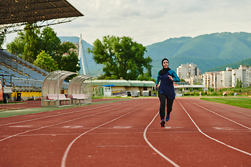 Image showing A muslim woman in a burqa sports muslim clothes running on a marathon course and preparing for upcoming competitions