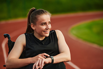 Image showing A woman with disability in a wheelchair checking a smart watch after a quick workout