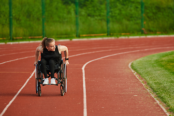 Image showing A woman with disablity driving a wheelchair on a track while preparing for the Paralympic Games