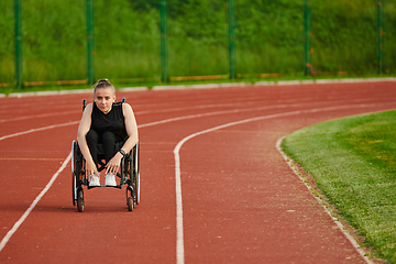 Image showing A woman with disablity driving a wheelchair on a track while preparing for the Paralympic Games