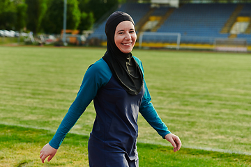 Image showing A Muslim woman with a burqa, an Islamic sportswoman resting after a vigorous training session on the marathon course. A hijab woman is preparing for a marathon competition