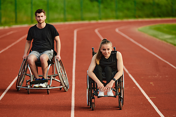 Image showing An inspiring couple with disability showcase their incredible determination and strength as they train together for the Paralympics pushing their wheelchairs in marathon track