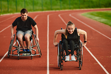 Image showing An inspiring couple with disability showcase their incredible determination and strength as they train together for the Paralympics pushing their wheelchairs in marathon track