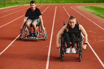 Image showing An inspiring couple with disability showcase their incredible determination and strength as they train together for the Paralympics pushing their wheelchairs in marathon track