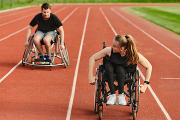 Image showing An inspiring couple with disability showcase their incredible determination and strength as they train together for the Paralympics pushing their wheelchairs in marathon track