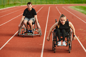 Image showing An inspiring couple with disability showcase their incredible determination and strength as they train together for the Paralympics pushing their wheelchairs in marathon track