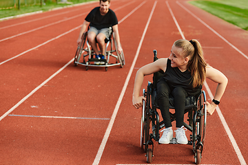 Image showing An inspiring couple with disability showcase their incredible determination and strength as they train together for the Paralympics pushing their wheelchairs in marathon track