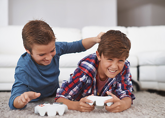 Image showing You always beat me. Shot of two young boys teasing each other while playing video games.