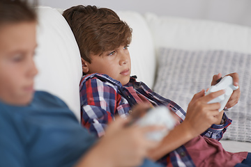 Image showing Loungin around. Shot of two tired young boys sitting and playing video games.