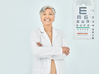 Image showing Portrait, ophthalmologist and woman arms crossed in hospital mockup space for healthcare of vision. Face, confident optometrist and happy doctor, mature expert optician and physician smile in India