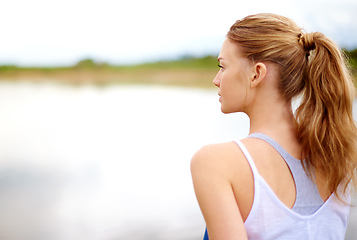 Image showing Its all about finding the calm in the chaos. Rearview shot of a young woman sitting outdoors.