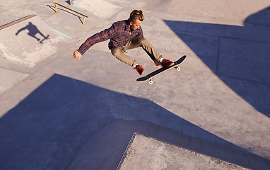 Image showing A rad day at the skate park. A young man doing tricks on his skateboard at the skate park.