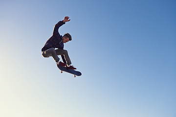 Image showing A rad day at the skate park. A young man doing tricks on his skateboard at the skate park.