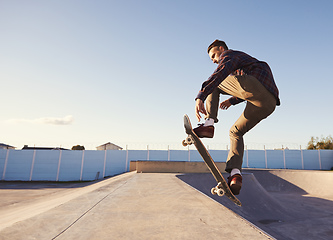 Image showing A rad day at the skate park. A young man doing tricks on his skateboard at the skate park.