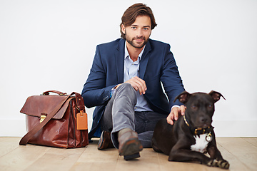 Image showing Happiness is coming home to your dog. Shot of a handsome man spending time with his dog after a day at the office.