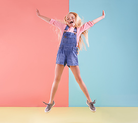 Image showing Wheee. A cute little girl jumping against a colorful background.