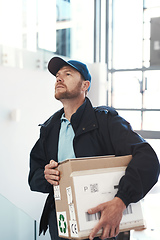 Image showing Hes on route to make a delivery. Shot of a handsome delivery man heading up a flight of stairs with a customers order.