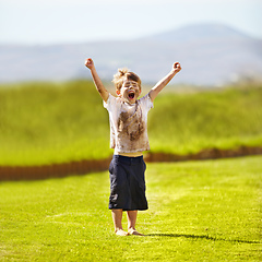 Image showing Im the winner. Cute little boy cheering while standing outdoors.