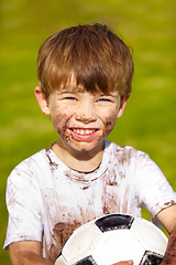 Image showing Want to play. Portrait of a muddy little boy holding a soccer ball.