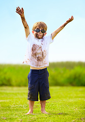 Image showing A muddy superhero. A little boy dressed as a superhero and covered in mud.