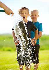 Image showing They dont need a pool to cool off. Little boys getting wet by a hose pipe while outdoors.