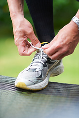 Image showing Nothing worse than loose laces.... Cropped shot of a jogger resting his foot on a chair while tying his shoelace.