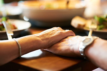 Image showing We have each other. Cropped shot of a couple holding hands in prayer at the table before eating.