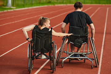 Image showing An inspiring couple with disability showcase their incredible determination and strength as they train together for the Paralympics pushing their wheelchairs in marathon track