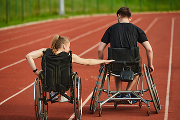 Image showing An inspiring couple with disability showcase their incredible determination and strength as they train together for the Paralympics pushing their wheelchairs in marathon track