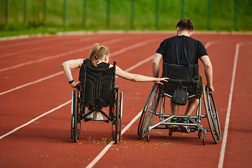 Image showing An inspiring couple with disability showcase their incredible determination and strength as they train together for the Paralympics pushing their wheelchairs in marathon track