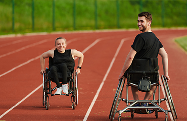 Image showing An inspiring couple with disability showcase their incredible determination and strength as they train together for the Paralympics pushing their wheelchairs in marathon track