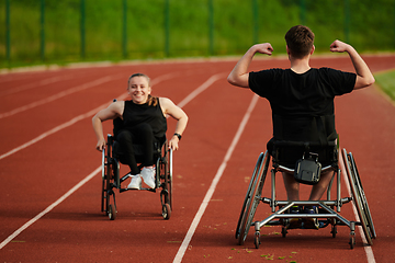 Image showing An inspiring couple with disability showcase their incredible determination and strength as they train together for the Paralympics pushing their wheelchairs in marathon track