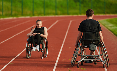 Image showing An inspiring couple with disability showcase their incredible determination and strength as they train together for the Paralympics pushing their wheelchairs in marathon track