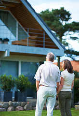 Image showing Finally we can afford our dream home. Rearview shot of a mature couple standing hand-in-hand in front of their home.