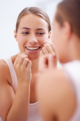 Image showing Dental hygiene is a priority. A young woman flossing her teeth.