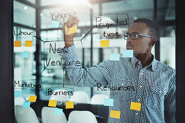 Image showing His strategies are bulletproof. Cropped shot of a handsome young businessman working on a glass wipe in the office.