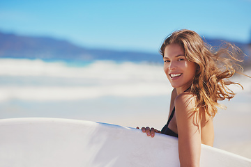 Image showing Surfs up. Portrait of a young surfer standing on the beach.