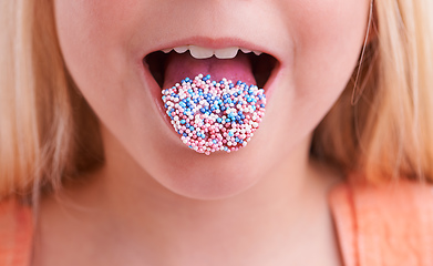 Image showing Mmmm, delicious. Cropped closeup of a little girl with candy on her tongue.